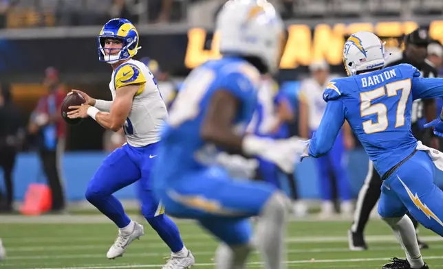 Los Angeles Rams quarterback Ty Simpson, left, scrambles during the first half of an NFL preseason football game against the Los Angeles Chargers Thursday, Aug. 27, 2026, in Inglewood, Calif. (AP Photo/Katie Chin)