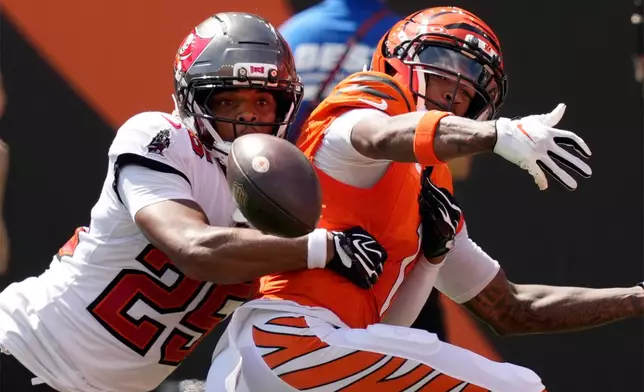Cincinnati Bengals wide receiver Ja'marr Chase, right, can't hang onto a pass as he is defended by Tampa Bay Buccaneers cornerback Jacob Parrish (25) in the first half of an NFL football game Sunday, Sept. 13, 2026, in Cincinnati. (AP Photo/Carolyn Kaster)
