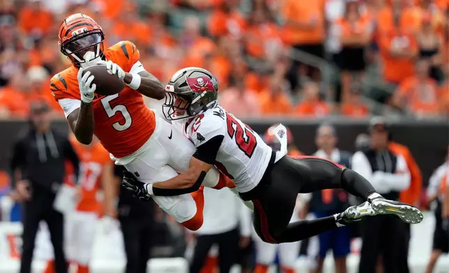 Cincinnati Bengals wide receiver Tee Higgins (5) catches a pass as he is defended by Tampa Bay Buccaneers cornerback Zyon McCollum (27) in the second half of an NFL football game Sunday, Sept. 13, 2026, in Cincinnati. (AP Photo/Carolyn Kaster)