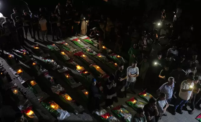 Mourners light candles by the bodies of Palestinians recovered from the rubble of homes demolished during the Israel-Hamas war in Gaza City, Saturday, Sept. 5, 2026. (AP Photo/Jehad Alshrafi)