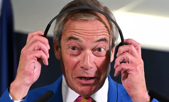 Reform Party Leader Nigel Farage puts on headphones at a press conference during the Reform party's annual conference at the National Exhibition Centre in Birmingham, England, Friday, Sept. 4, 2026. (AP Photo/Thomas Krych)
