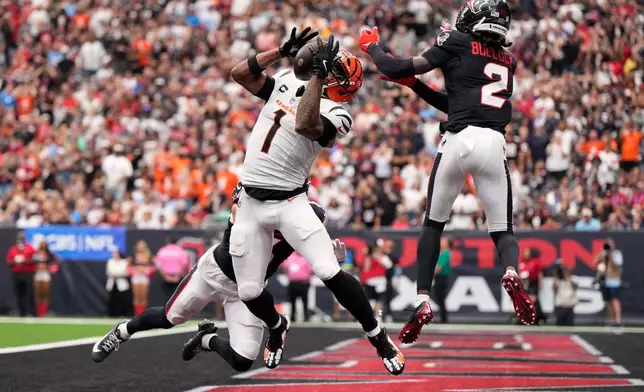 Cincinnati Bengals wide receiver Ja'marr Chase (1) catches a pass for a touchdown as Houston Texans safety Reed Blankenship, behind, and safety Calen Bullock (2) try to defend during the second half of an NFL football game in Houston, Sunday, Sept. 20, 2026. (AP Photo/Ashley Landis)