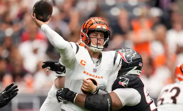 Cincinnati Bengals quarterback Joe Burrow (9), left, throws as he is tackled by Houston Texans defensive tackled Sheldon Rankins (98), right, during the first half of an NFL football game in Houston, Sunday, Sept. 20, 2026. (AP Photo/Ashley Landis)