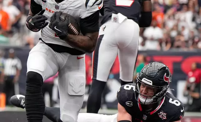 Cincinnati Bengals wide receiver Ja'marr Chase, left, reacts after catching a pass for a touchdown as Houston Texans safety Reed Blankenship, (6) and safety Calen Bullock (2) tried to defend during the second second of an NFL football game in Houston, Sunday, Sept. 20, 2026. (AP Photo/Ashley Landis)