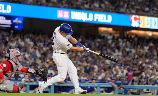 Los Angeles Dodgers' Will Smith, right, hits a solo home run as Cincinnati Reds catcher Jose Trevino watches during the first inning of a baseball game Tuesday, Sept. 8, 2026, in Los Angeles. (AP Photo/Mark J. Terrill)