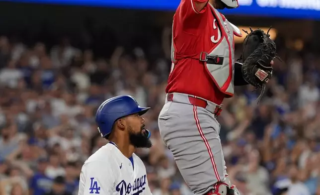 Cincinnati Reds catcher Jose Trevino, right, celebrates after tagging out Los Angeles Dodgers' Teoscar Hernández as Hernández tried to score on an inside-the-park home run during the third inning of a baseball game Tuesday, Sept. 8, 2026, in Los Angeles. (AP Photo/Mark J. Terrill)