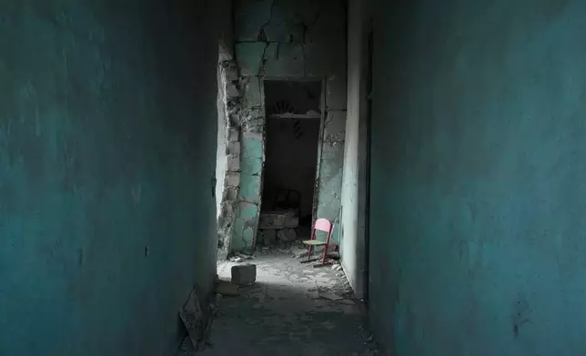 A small empty chair stands in a dim hallway at the Shajareh Tayyebeh school, hit by a Feb. 28 U.S. airstrike in Minab, southern Iran, Monday, Sept. 7, 2026. (AP Photo/Vahid Salemi)