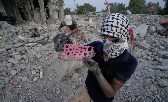 A volunteer shows a child's drawing stencil recovered as volunteers search the rubble of the Shajareh Tayyebeh school, hit on Feb. 28 by a U.S. airstrike in Minab, southern Iran, Monday, Sept. 7, 2026. (AP Photo/Vahid Salemi)