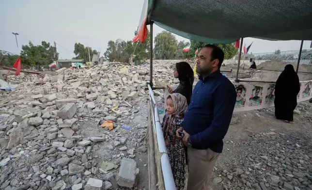 People look at the rubble at the Shajareh Tayyebeh school where portraits are displayed of the children and teachers killed by a Feb. 28 U.S. airstrike in Minab, southern Iran, Monday, Sept. 7, 2026. (AP Photo/Vahid Salemi)