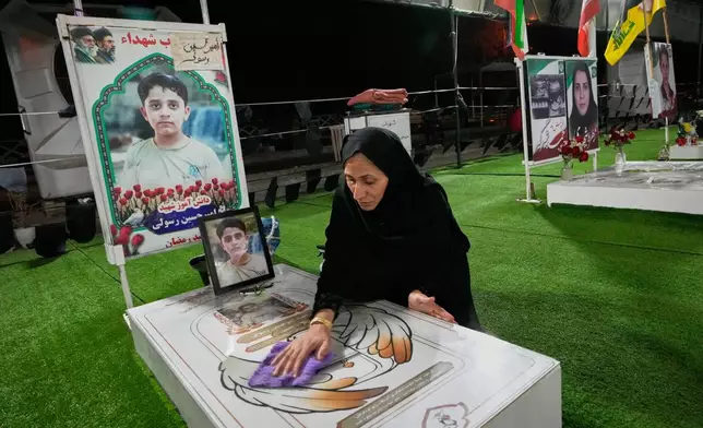 A woman cleans the grave of a child killed in a Feb. 28 U.S. airstrike on Shajareh Tayyebeh school in a section of Minab's cemetery set aside for those killed at the school in southern Iran, Monday, Sept. 7, 2026. (AP Photo/Vahid Salemi)