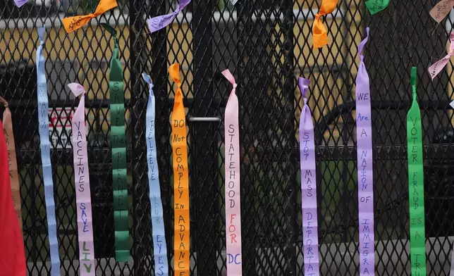 Protest ribbons are tied to a fence at Lafayette Park, near the White House, Tuesday, Aug. 25, 2026, in Washington. (AP Photo/Alex Brandon)
