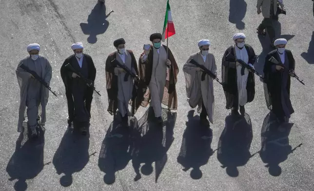 Shiite clerics carrying rifles march during the state-organized "Janfada," or "Sacrifice for Iran," military-style parade at Revolution Square in Tehran, Iran, Friday, Sept. 18, 2026. (AP Photo/Vahid Salemi)