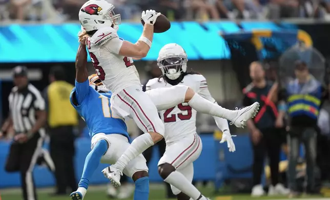 Arizona Cardinals safety Andrew Wingard, top, intercepts a pass intended for Los Angeles Chargers wide receiver Derius Davis, left, during the second half of an NFL football game, Sunday, Sept. 13, 2026, in Inglewood, Calif. (AP Photo/Gregory Bull)