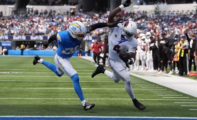 Arizona Cardinals running back Jeremiyah Love, right, runs for a touchdown against Los Angeles Chargers cornerback Cam Hart (20) during the first half of an NFL football game, Sunday, Sept. 13, 2026, in Inglewood, Calif. (AP Photo/Gregory Bull)