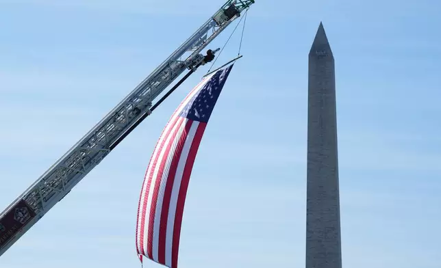 The U.S. flag is displayed during the Tunnel to Towers Foundation event for the 25th Anniversary of 9/11, on the Ellipse near the Washington monument, rear, in Washington, Tuesday, Sept. 8, 2026. (AP Photo/Jacquelyn Martin)