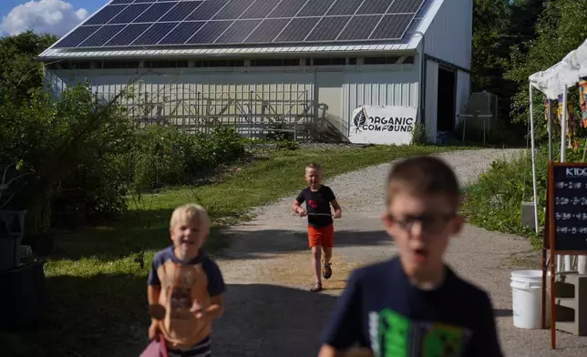 A group of kids play at Organic Compound during the farm's annual event, "Halfway to Harmony," in Faribault, Minn., Saturday, June 20, 2026. (AP Photo/Jessie Wardarski)
