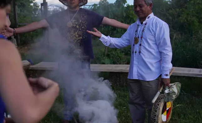 Reginaldo Haslett-Marroquin, right, a farmer and agronomist, participates in a solstice ceremony at Organic Compound in Faribault, Minn., on Saturday, June 20, 2026. (AP Photo/Jessie Wardarski)