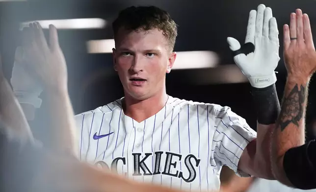 Colorado Rockies' TJ Rumfield is congratulated as he returns to the dugout after hitting a two-run homw erun off Baltimore Orioles relief pitcher Luis De Leon in the seventh inning of a baseball game Tuesday, Sept. 1, 2026, in Denver. (AP Photo/David Zalubowski)