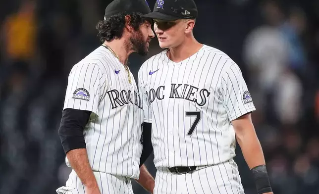 Colorado Rockies relief pitcher Jordan Romano, left, congratulates first baseman TJ Rumfield after defeating the Baltimore Orioles in a baseball game Tuesday, Sept. 1, 2026, in Denver. (AP Photo/David Zalubowski)