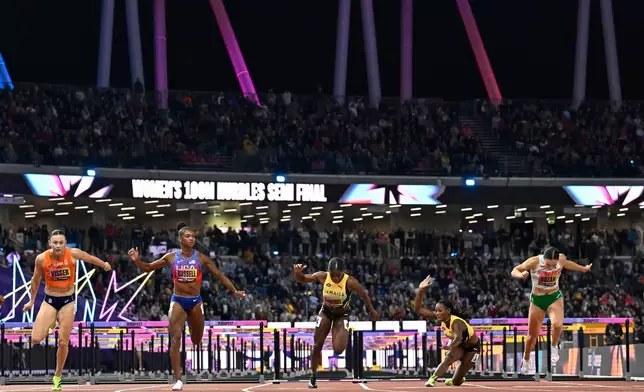 Masai Russell, of the United States, second right, wins a women's 100 meters hurdles semifinal ahead of Nadine Visser, of the Netherlands, left, and Ackera Nugent, of Jamaica, who falls during the World Athletics Ultimate Championship in Budapest, Hungary, Friday, Sept. 11, 2026. (AP Photo/Denes Erdos)