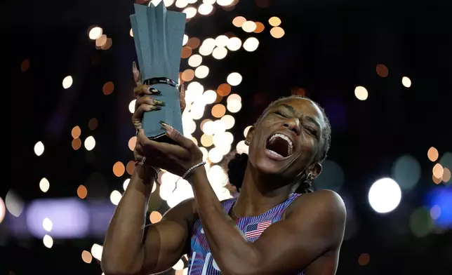 Melissa Jefferson-Wooden, of the United States, poses with her trophy after winning the women's 100 meters final at the World Athletics Ultimate Championship in Budapest, Hungary, Saturday, Sept. 12, 2026. (AP Photo/Matthias Schrader)