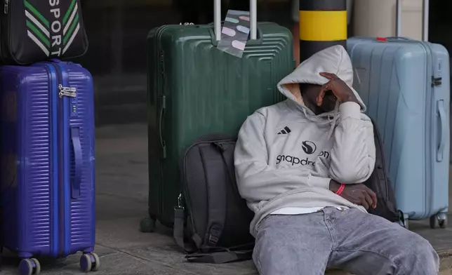 A passenger sleeps as he waits for his delayed flight during a workers strike at Jomo Kenyatta International Airport in Nairobi, Kenya, Monday, Aug. 31, 2026. (AP Photo/Brian Inganga)