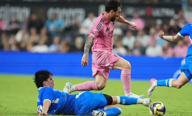 Cruz Azul midfielder Amaury García, left, falls to the field after he goes for the ball against Inter Miami forward Lionel Messi, right, during the first half of the Campeones Cup soccer match, Wednesday, Sept. 16, 2026, in Miami. (AP Photo/Lynne Sladky)
