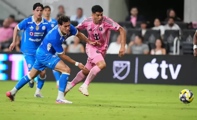 Cruz Azul defender Jesús Orozco, left and Inter Miami forward Luis Suárez, right, chase the ball during the first half of the Campeones Cup soccer match, Wednesday, Sept. 16, 2026, in Miami. (AP Photo/Lynne Sladky)