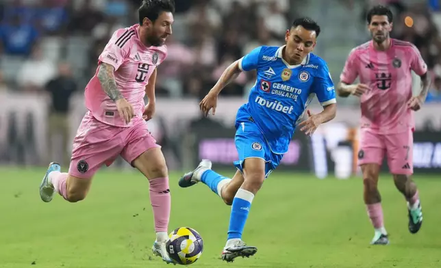 Inter Miami forward Leo Messi, left, runs with the ball as Cruz Azul midfielder Carlos Rodríguez defends during the first half of the Campeones Cup soccer match, Wednesday, Sept. 16, 2026, in Miami. (AP Photo/Lynne Sladky)