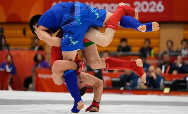 Behruz Khurshedzoda of Tajikistan, bottom, competes against Kadyrbek Shinbayev of Kazakhstan during their men's modern 71kg mixed martial arts final at the Asian Games in Nagoya, Japan, Tuesday, Sept. 22, 2026. (AP Photo/Dita Alangkara)