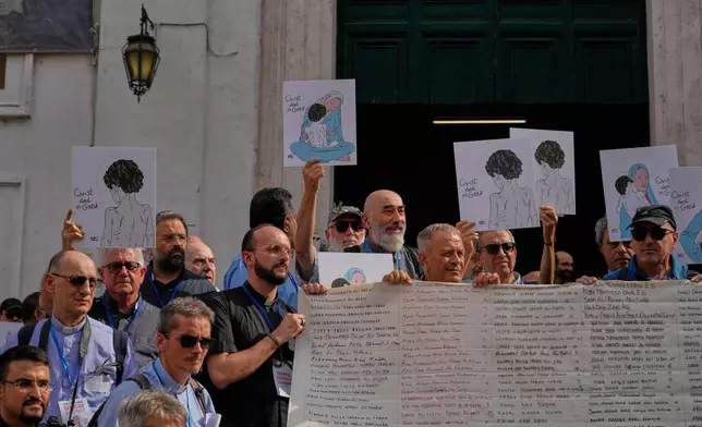 Priests from various countries, members of the "Priests Against Genocide" network, carry a shroud bearing the names of 300 Palestinian and Lebanese children whom organizers say were killed by the Israeli military after ceasefires were declared, during a demonstration near St. Peter's Square at the Vatican, Tuesday, Sept. 22, 2026. (AP Photo/Gregorio Borgia)