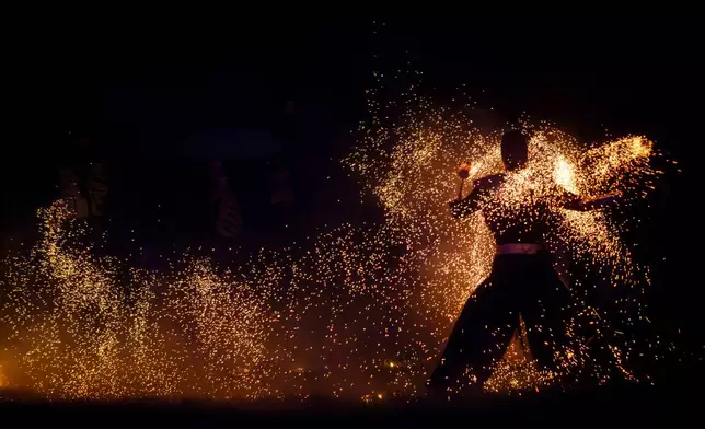 People participate in fire rituals during the Autumn Equinox celebration in Vilnius, Lithuania, Tuesday, Sept. 22, 2026. (AP Photo/Mindaugas Kulbis)