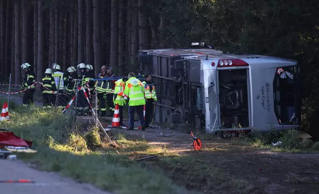 Emergency services at the scene after a tourist bus veered off a highway, in Buchloe, Germany, Sunday, Sept. 27, 2026. (Karl-Josef Hildenbrand/dpa via AP)