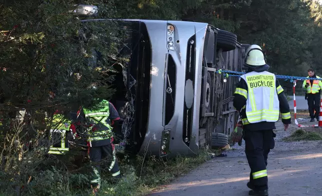 Emergency services at the scene after a tourist bus veered off a highway, in Buchloe, Germany, Sunday, Sept. 27, 2026. (Karl-Josef Hildenbrand/dpa via AP)