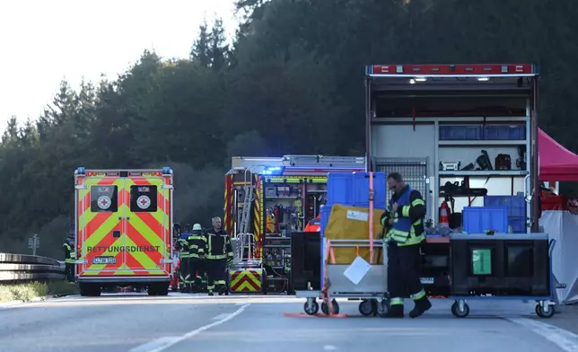 Emergency services at the scene after a tourist bus veered off a highway, in Buchloe, Germany, Sunday, Sept. 27, 2026. (Karl-Josef Hildenbrand/dpa via AP)