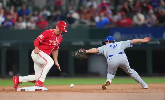 Toronto Blue Jays second baseman Josh Smith (9) is unable to handle a throw from teammate catcher Alejandro Kirk, not visible, as Texas Rangers' Wyatt Langford, left, steals second base during the second inning of a baseball game Friday, Sept. 18, 2026, in Arlington, Texas. (AP Photo/Julio Cortez)