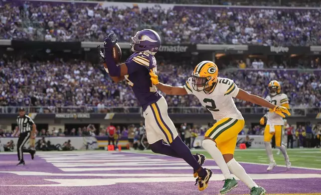 Minnesota Vikings wide receiver Justin Jefferson (18) catches a touchdown pass as Green Bay Packers cornerback Brandon Cisse (2) defends during the first half of an NFL football game, Sunday, Sept. 13, 2026, in Minneapolis, Minn. (AP Photo/Abbie Parr)