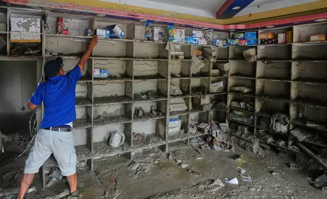 A resident salvages his belongings from his house filled with mud and debris in Devighat in Nepal's Nuwakot district, Saturday, Aug. 29, 2026, following the Aug. 26 flash floods. (AP Photo/Rajesh Kumar Singh)