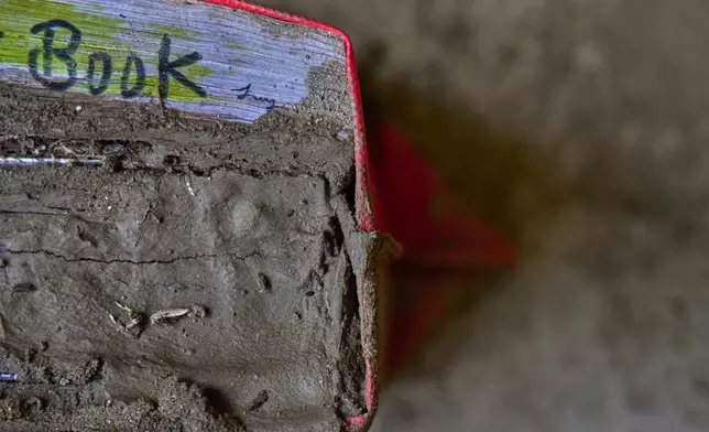 A school bag is full of mud brought in by the recent flash floods, at the Shree Bagheswori Madhyamik School in Galchhi, Dhading district of Nepal Sunday, Aug. 30, 2026. (AP Photo/Niranjan Shrestha)