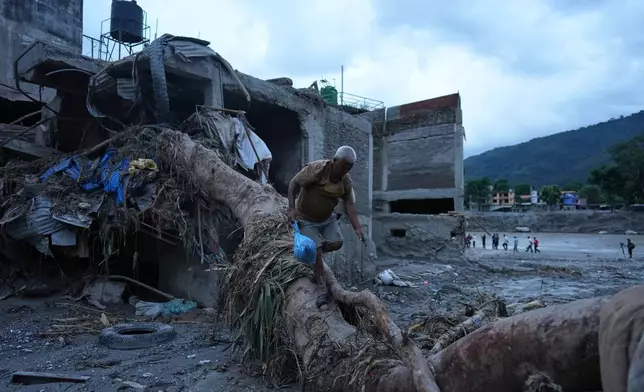 A resident salvages belongings from his damaged home after flash flooding in the Devighat area of Nuwakot district in Nepal, Monday, Aug. 31, 2026. (AP Photo/Rajesh Kumar Singh)