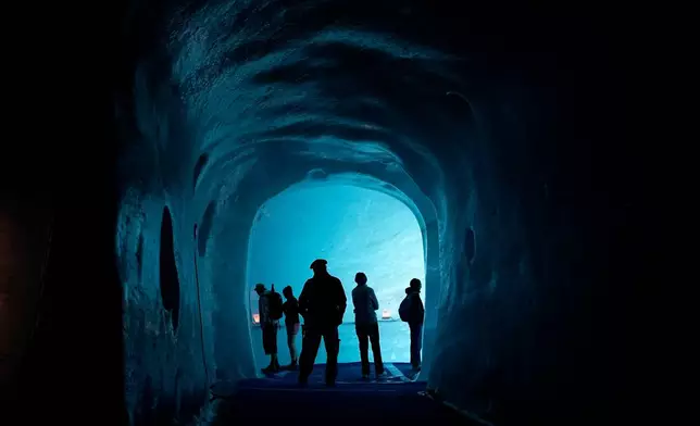Tourists walk in the ice cave of the 'Mer de Glace' glacier, at the Montenvers station in Chamonix, France, Saturday, Sept. 5, 2026. (AP Photo/Laurent Cipriani)