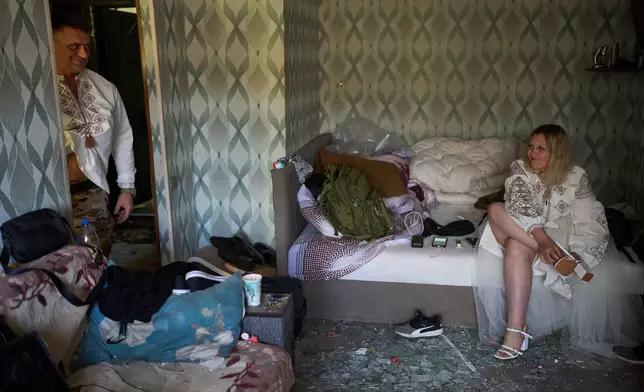 Liudmyla Ryzhak, right, and her fiancee Leonid Ryzhak get ready in their damaged apartment for their wedding ceremony following a Russian missile and drone attack in Kyiv, Ukraine, early Tuesday, Sept. 8, 2026. (AP Photo/Francisco Seco)