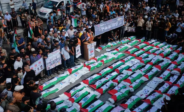 Mourners gather around the flag-draped bodies of Palestinians killed in Israeli strikes during the war with Hamas, whose remains were recently recovered from the rubble, in Gaza City, Sunday, Sept. 6, 2026. (AP Photo/Jehad Alshrafi)
