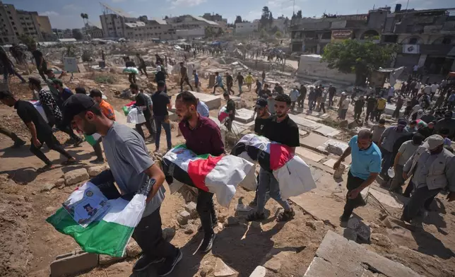Mourners carry the flag-draped bodies of Palestinians killed in Israeli strikes in the war with Hamas, whose remains were recently recovered from the rubble, during their funeral in Gaza City, Sunday, Sept. 6, 2026. (AP Photo/Jehad Alshrafi)