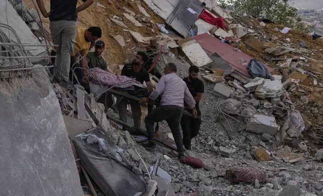 People carry a body of a person who was killed at a house that was hit by an Israeli airstrike in Arab Salim village, southern Lebanon, Sunday, Sept. 6, 2026. (AP Photo/Mohammed Zaatari)