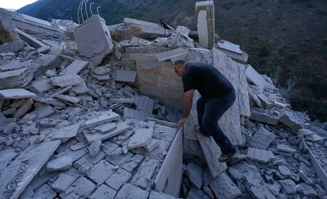 A man searches between the rubble of a destroyed house that was hit by an Israeli airstrike in Arab Salim village, southern Lebanon, Sunday, Sept. 6, 2026. (AP Photo/Mohammed Zaatari)