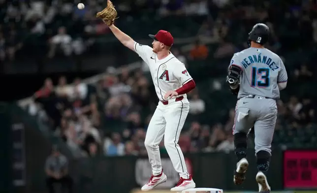 Arizona Diamondbacks first baseman Pavin Smith, left, makes a catch at first base to get Miami Marlins' Heriberto Hernández (13) out during the first inning of a baseball game, Tuesday, Sept. 15, 2026, in Phoenix. (AP Photo/Ross D. Franklin)