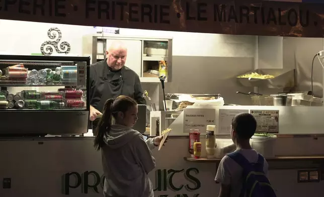 Martial Realland serves customers from his food truck in Saint-Just-en-Chaussee, France, Wednesday Sept. 23, 2026. (AP Photo/John Leicester)