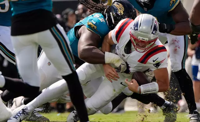 Jacksonville Jaguars defensive tackle Davon Hamilton (52) tackles New England Patriots quarterback Drake Maye (10) in the first half during an NFL football game in Jacksonville, Fla., Sunday, Sept. 27, 2026. (AP Photo/Mike Stewart)