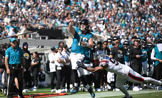 Jacksonville Jaguars quarterback Trevor Lawrence (16) passes against New England Patriots linebacker Elijah Ponder (91) in the second half during an NFL football game in Jacksonville, Fla., Sunday, Sept. 27, 2026. (AP Photo/Phelan M. Ebenhack)